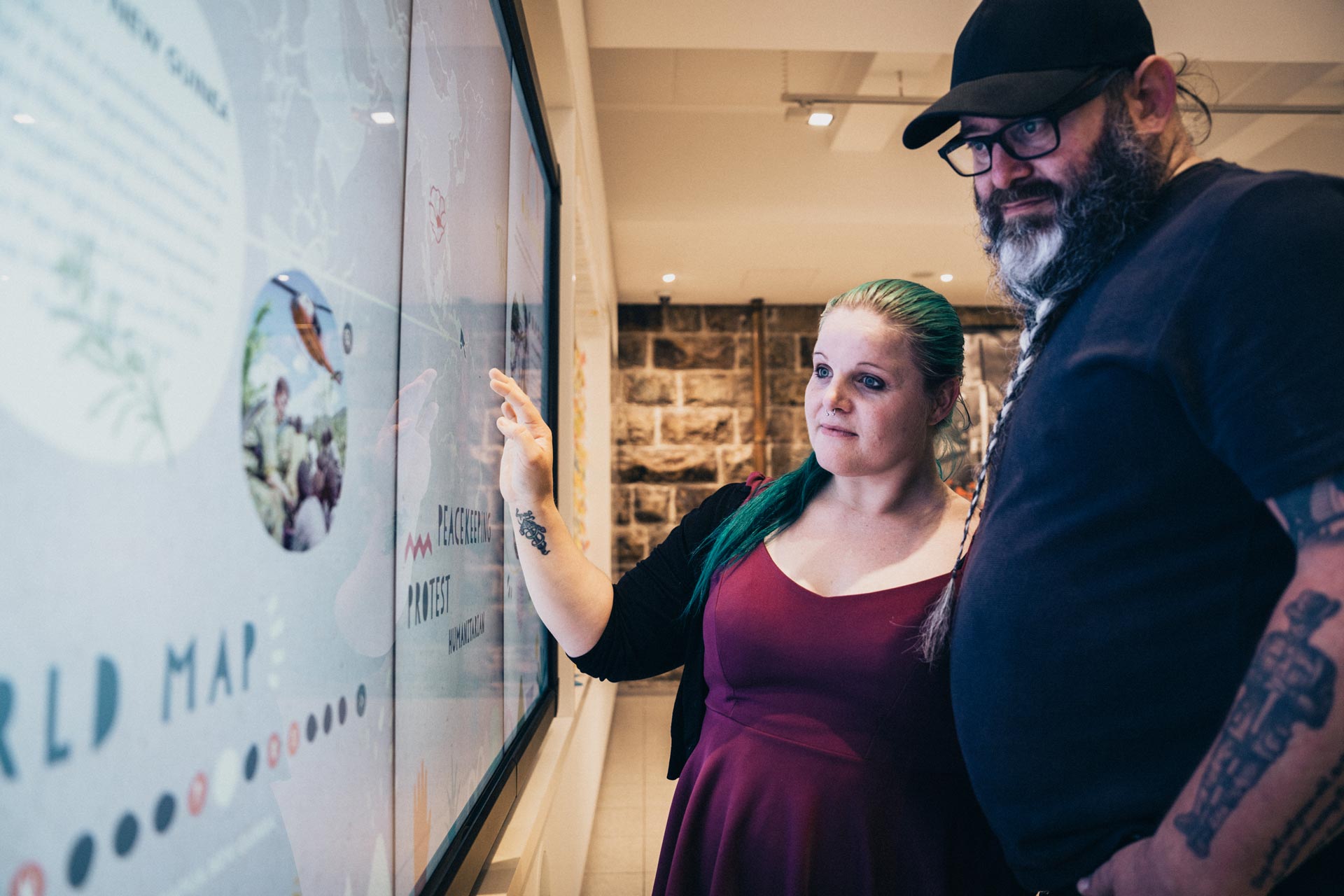 Man and woman using touch screens inside a gallery.