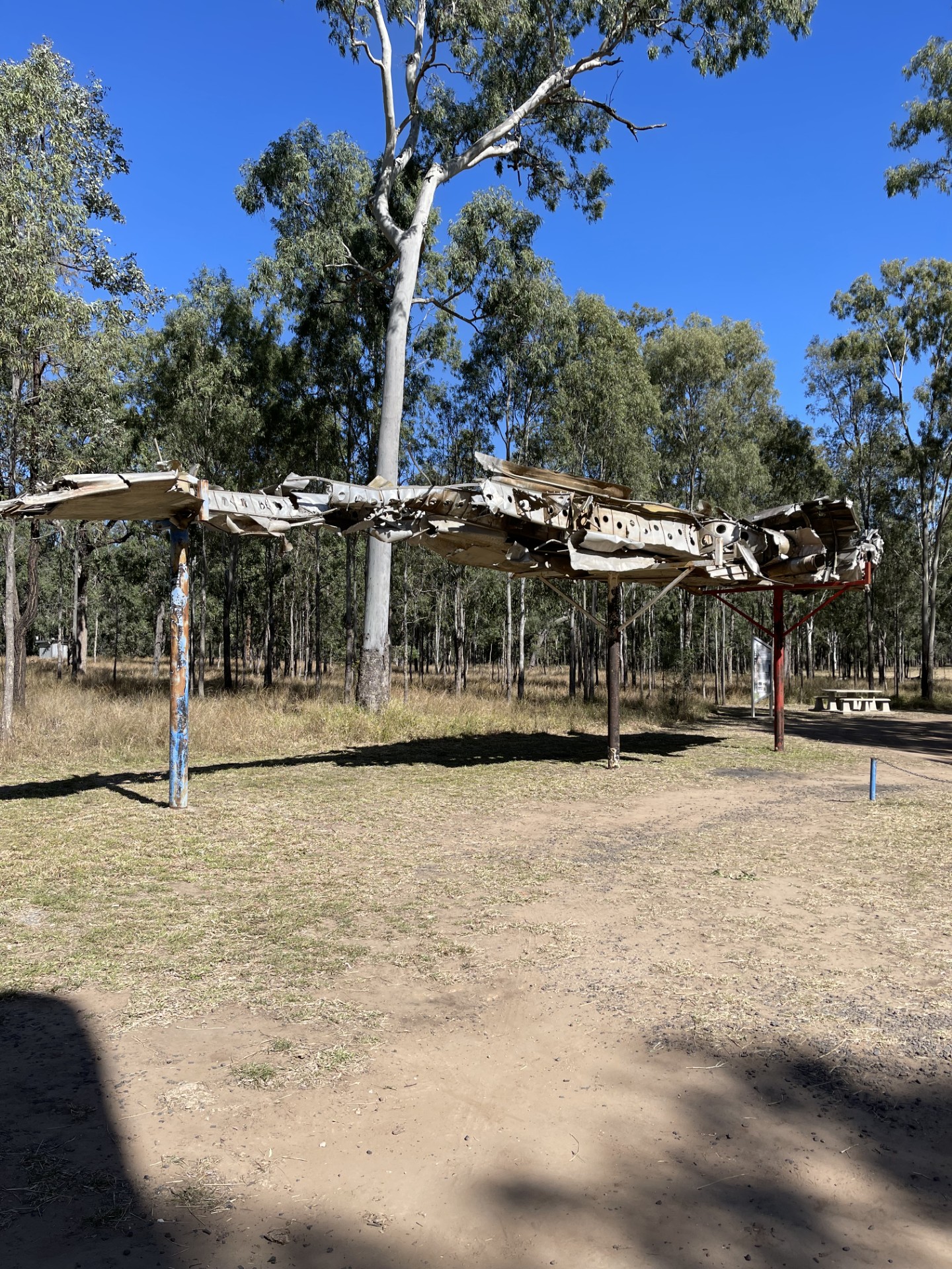 A wrecked wing mounted atop three poles
