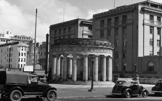 Black and white photograph of Anzac Memorial with old cars in the foreground.