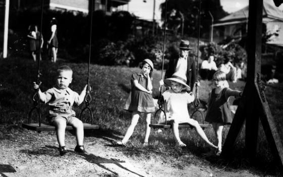Black and white image of children playing in a playground