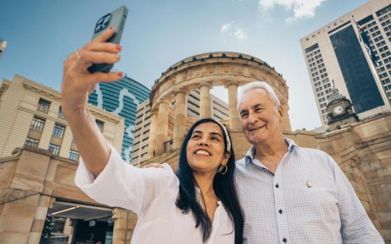 Man and woman taking a selfie on a mobile phone outside Anzac Square.