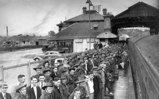 A large group of trainee soldiers, most dressed in full uniform with slouch hats, fill the platform of Roma Street Station.