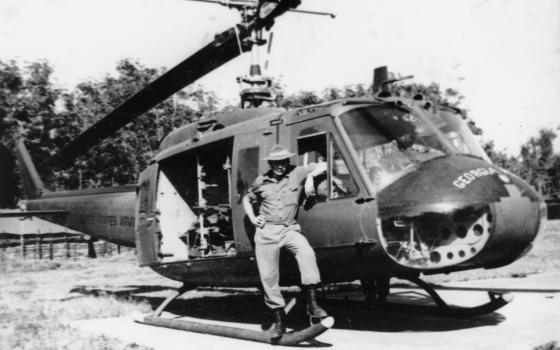 Corporal Victor Patty standing by a medivac Huey helicopter, Vietnam 1967
