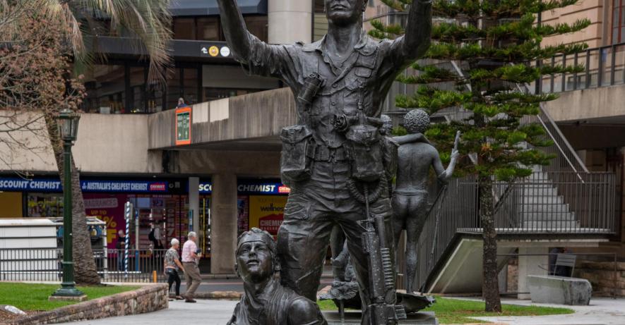 Statue of soldier directing a helicopter for a wounded soldier.
