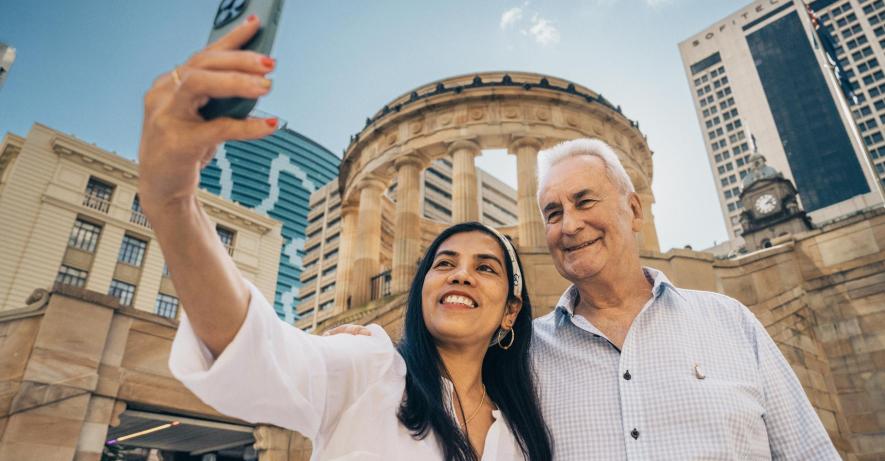 Man and woman taking a selfie on a mobile phone outside Anzac Square.